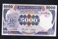Front and back of an uncirculated 1986 Uganda 5000 Shillings banknote featuring the coat of arms and Makerere University.
