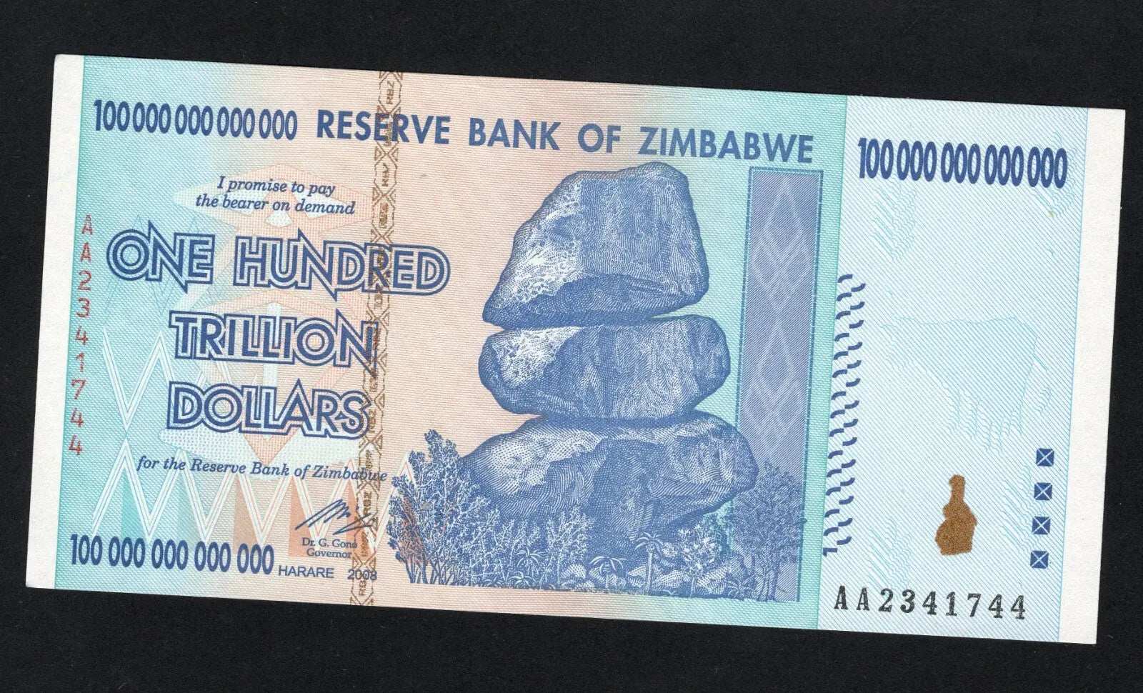 front of Zimbabwe 100 Trillion Dollar banknote. Genuine, AUNC AA Serial Number UV checked