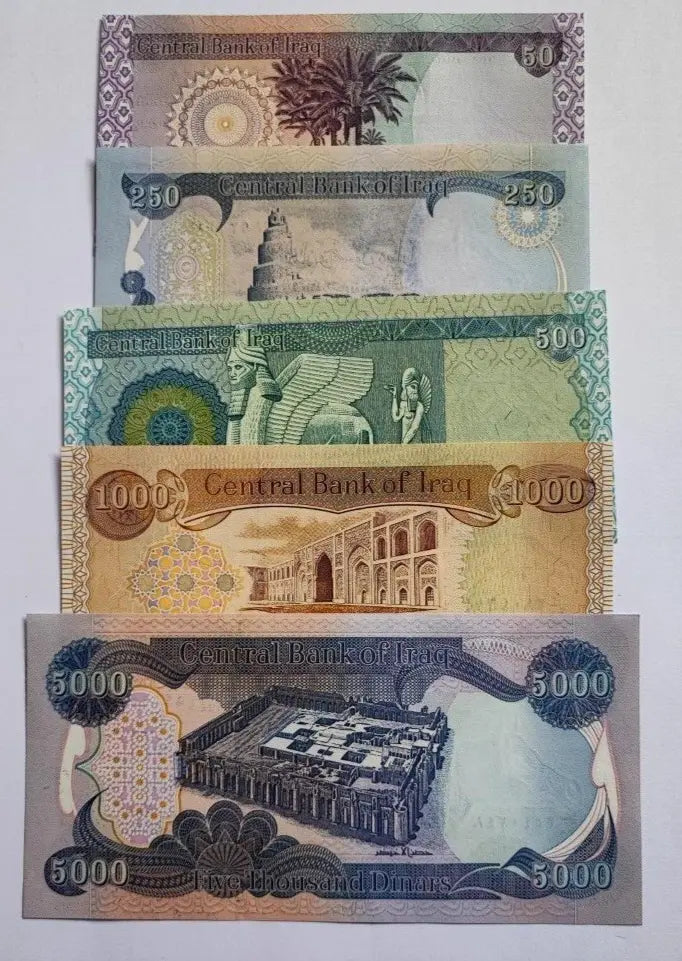 Assorted Iraqi dinar banknotes featuring landmarks and historic designs