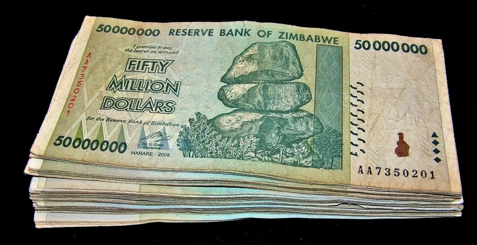Stack of Zimbabwe 50 million dollar banknotes featuring balancing rocks, collectible currency