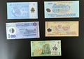 Assorted world banknotes from Vietnam, Romania, Iraq, and others on a black background.