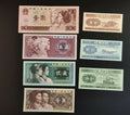 Assorted Chinese banknotes featuring portraits and transport illustrations on black background