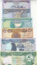 Stack of Iraqi dinar banknotes with Arabic script and historical landmarks