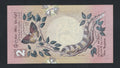 Two rupees banknote with a lizard and butterfly design on a pink background