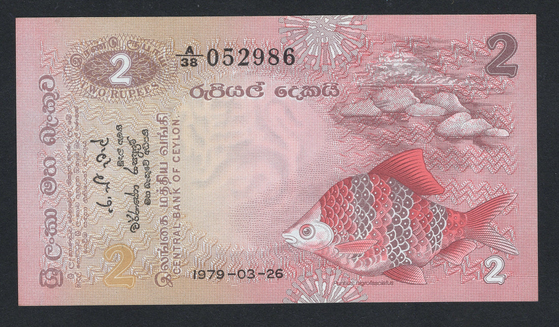 Two rupee banknote from Ceylon with a fish illustration on a pink background
