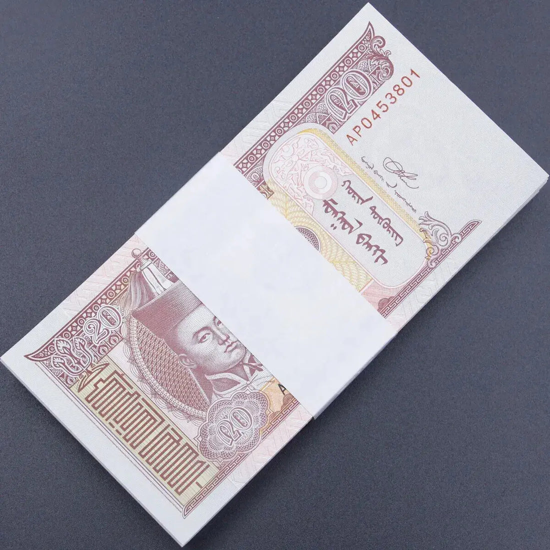 A complete bank bundle of 100 uncirculated 2018 Mongolia 20 Tögrög banknotes featuring Damdin Sükhbaatar and grazing horses.