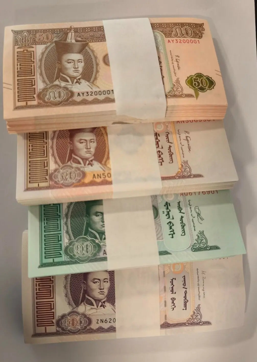Wholesale bundles of 400 uncirculated Mongolian Tugrik banknotes, including 10, 20, 50, and 100 denominations featuring Damdin Sükhbaatar.